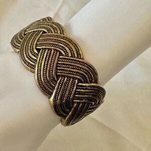 Gold tone hinged braided bangle bracelet